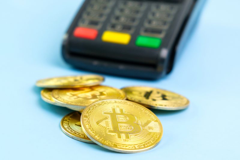 bitcoin-coins-near-pos-payment-terminal-on-the-blu-2023-11-27-05-15-22-utc.jpg